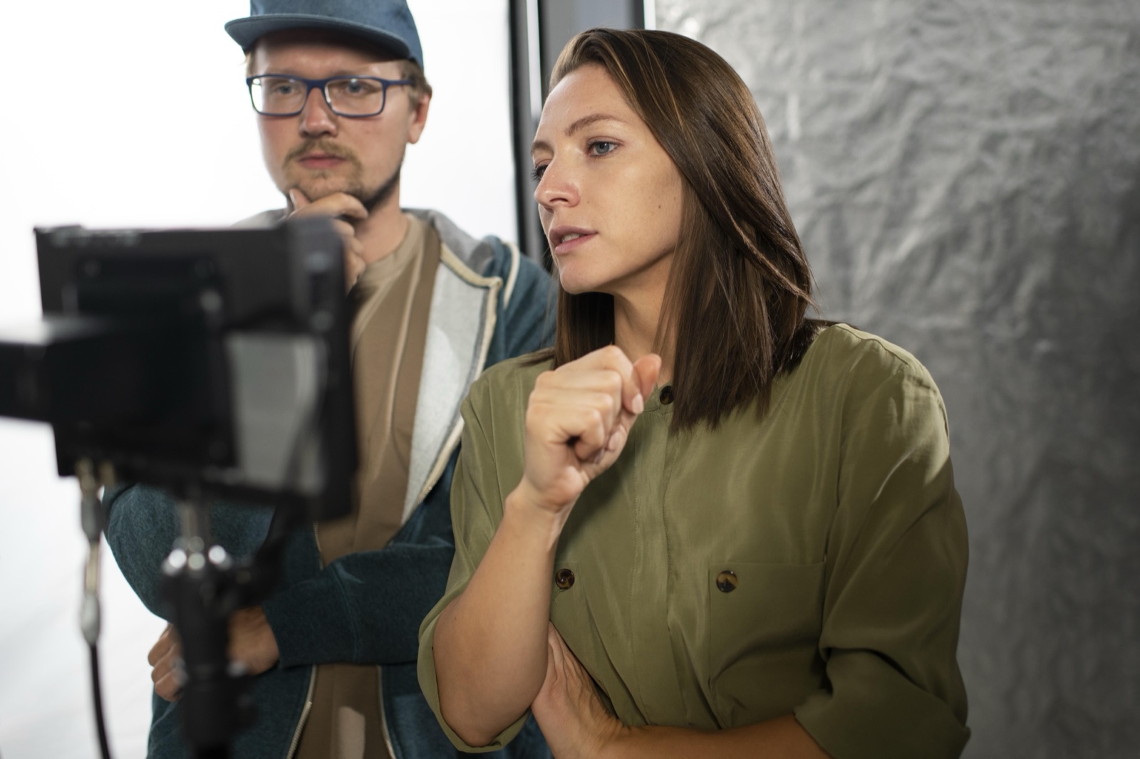 Set de filmagem: câmera de cinema em primeiro plano e a equipe conversando ao fundo